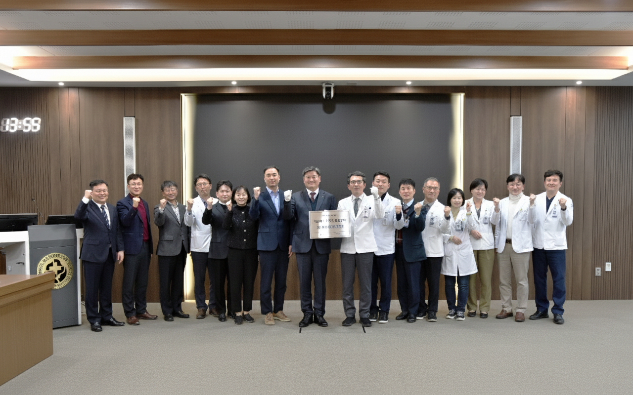 화순전남대학교병원 대강당에서 관계자들이 한 줄로 나란히 서서 기념촬영을 하고 있는 모습이다. 병원 관계자와 의료진, 유관기관 참석자들이 함께 주먹을 들어 올리며 ‘의료데이터 안심활용센터’ 지정에 대한 의지를 표현하고 있으며, 중앙에는 ‘의료데이터 안심활용센터 지정’ 관련 현판을 들고 있다. 일부 참석자는 흰색 가운을 착용한 의료진으로 보이며, 병원과 연구기관, 행정기관이 함께 참여한 공식 행사 분위기가 느껴진다. 해당 사진은 화순전남대학교병원이 호남권 의료데이터 안심활용센터로 지정되어 암 공공·임상연구 거점 역할을 수행하게 되었음을 상징적으로 보여준다.